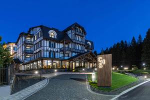 a large building with a sign in front of it at Crona SPA Karpaty in Skhidnitsa