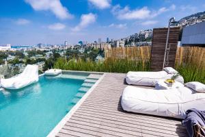 een zwembad met kussens op een houten terras bij SERENE - Infinity Cview pool - 4 bedrooms Luxury Penthouse in Haifa