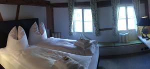 1 dormitorio con 1 cama con sábanas y almohadas blancas en Haus in der Zitronengasse, en Lindau