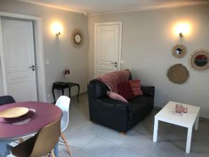 ein Wohnzimmer mit einem schwarzen Sofa und einem Tisch in der Unterkunft La Cigaliere en Cote Vermeille in Latour-Bas-Elne