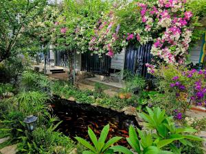 a garden with pink flowers hanging from a building at Window 2 Hotel in Kon Tum