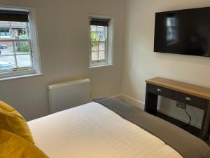 a bedroom with a bed and a flat screen tv at Swan House - 5 x Executive Apartments - Central Bawtry in Bawtry