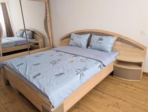 Un dormitorio con una cama con un edredón azul. en Lovely 2-bedroom flat in the heart of Druskininkai, en Druskininkai