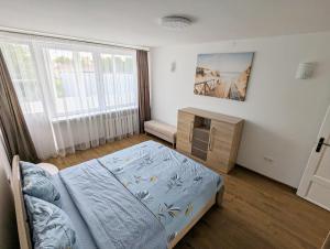 ein Schlafzimmer mit einem Bett, einer Kommode und einem Fenster in der Unterkunft Lovely 2-bedroom flat in the heart of Druskininkai in Druskininkai