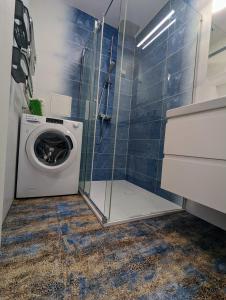 a washing machine in a bathroom with a shower at Lovely 2-bedroom flat in the heart of Druskininkai in Druskininkai
