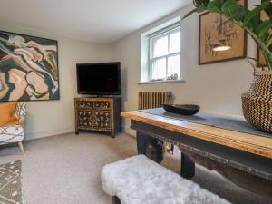 a living room with a table and a tv at Artists Hideaway in Battle