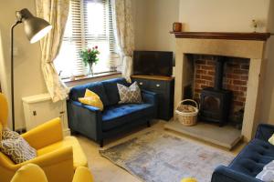 sala de estar con sofá azul y chimenea en No2 Woodland View, en Bakewell