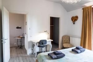 a bedroom with a bed and a desk and a table at Villa De Alberti in Vergiate