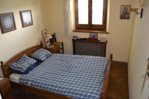 a bedroom with a bed with a blue checkered blanket at Acogedor apartamento con jardín en Ger in Ger
