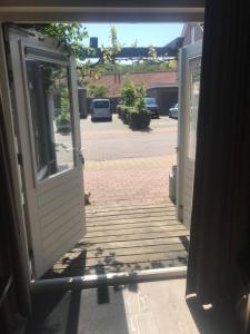 eine offene Tür, die zu einem Innenhof mit einer Auffahrt führt in der Unterkunft Bed & Breakfast Klokgaaf in De Koog