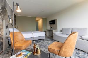 une chambre d'hôtel avec un lit et un canapé dans l'établissement Fletcher Hotel Restaurant Hellendoorn, à Hellendoorn