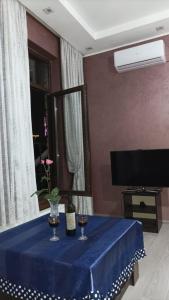 einem blauen Tisch mit zwei Weingläsern und einem TV in der Unterkunft Panorama of Tbilisi in Tbilisi City