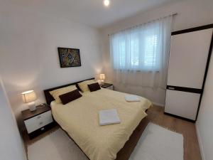 ein Schlafzimmer mit großem Bett und Fenster in der Unterkunft Apartment Dina in Malinska