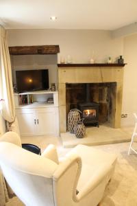 a living room with a fireplace and a chair at The Nook in Bakewell