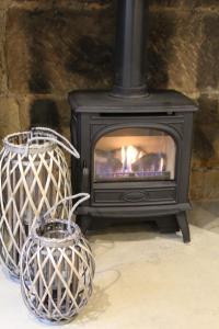 a black stove with a fire in a room at The Nook in Bakewell