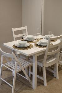 a white table with chairs and plates and wine glasses at The Nook in Bakewell