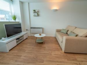 a living room with a couch and a table at Pass the Keys One Bed City Centre Apartment in Nottingham