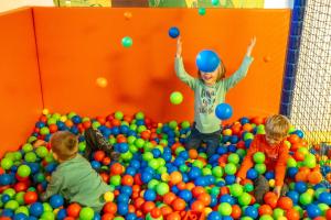 een groep kinderen die spelen in een stapel ballen bij Alpen Adria Hotel & Spa in Presseggersee