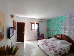 a bedroom with a bed and a television in it at Capriccio in Grand-Bassam