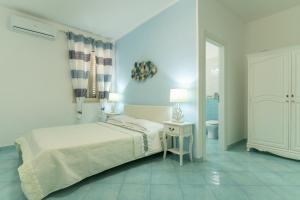 a white bedroom with a bed and a toilet at Casa di Nonno Gerlando in Lampedusa