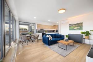 a living room with a blue couch and a table at Apartment by the golf course in Hrubá Borša