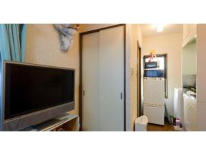 salon z telewizorem z płaskim ekranem i drzwiami w obiekcie Cosmo Mercy N-1 / Vacation STAY 12990 w Tokio