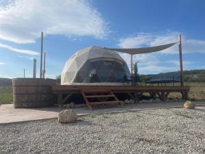 a yurt with a wooden table and a picnic table at Baladome in Dörgicse