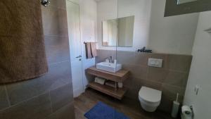 a bathroom with a sink and a toilet and a mirror at Lustica Lux in Tivat