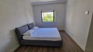 a small bedroom with a bed with a window at Lustica Lux in Tivat