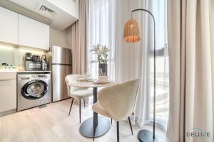 a kitchen with a table and chairs in a room at Graceful Studio at Mesk 1 Midtown Dubai Production City by Deluxe Holiday Homes in Dubai