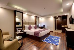 帕哈尔加姆The Chinar Resort & Spa, Pahalgam的一间卧室配有一张床、一把椅子和一张沙发