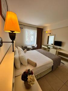 a hotel room with a bed and a table with a lamp at Smart Stay Beach Bodrum -All Inclusive in Gümbet