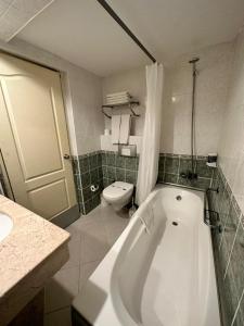 a bathroom with a bath tub and a toilet at Smart Stay Beach Bodrum -All Inclusive in Gümbet