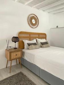 a bedroom with a bed and a table with a mirror at Oculus Mykonos Suite II in Mikonos