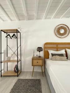 a bedroom with a bed and a table and a mirror at Oculus Mykonos Suite II in Mikonos