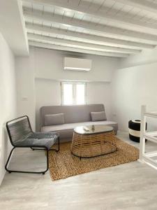a living room with a couch and a table and a chair at Oculus Mykonos Suite II in Mikonos