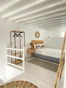 a bedroom with a bed and a clock on the wall at Oculus Mykonos Suite II in Mikonos