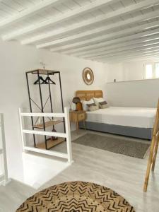 a white bedroom with a bed and a shelf at Oculus Mykonos Suite II in Mikonos