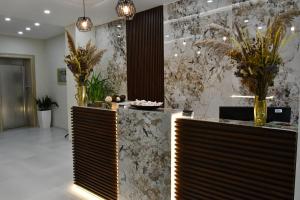 - un hall avec un mur en marbre orné de plantes en pot dans l'établissement Elite Hotel, à Golem