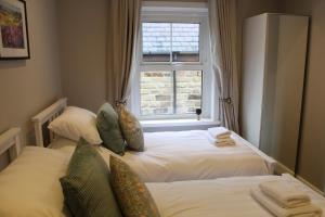a bedroom with two beds in front of a window at No4 Chapel Row in Bakewell