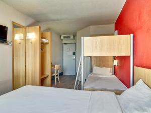 ジェルザにあるB&B HOTEL Clermont-Ferrand Gerzatのベッド2台と二段ベッド1組が備わる客室です。