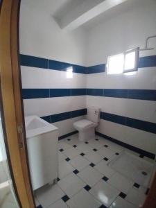 a bathroom with blue and white striped walls and a toilet at Espace la Détente in El Jadida