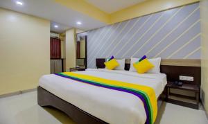 1 dormitorio con 1 cama grande con una manta colorida en Itsy By Treebo - Prince Regency, en Pune