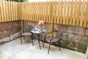 2 chaises et une table avec un vase de fleurs. dans l'établissement No4 Chapel Row, à Bakewell