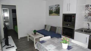 - un petit salon avec un canapé et une table dans l'établissement apartamento rio salado, à Conil de la Frontera