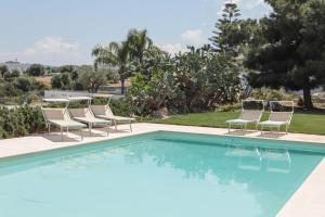 una piscina con tumbonas y una piscina en Villa Dyria exclusive swimming pool, en Monopoli