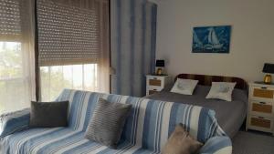 a bedroom with two beds and a couch and a window at Apartment Ana in Opatija
