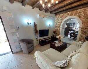 a living room with a couch and a tv at Neriana Villa - Garden Paradise in Chania Town