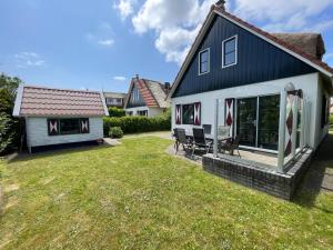 a black and white house with a yard at Buitenplaats 108 in Callantsoog