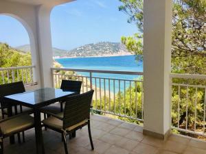 balcón con mesa, sillas y vistas al océano en Apartamentos Aguas Blancas en Santa Eulalia del Río